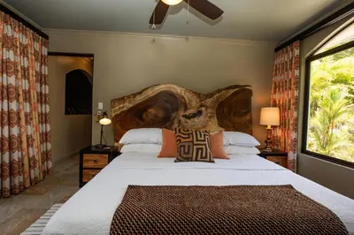 a bedroom with a large bed with a wooden headboard at Villa Palmeras with jungle views pool near MA in Quepos