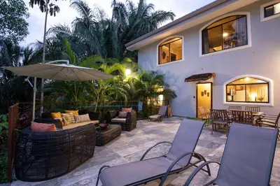a patio with two chairs and an umbrella at Villa Palmeras with jungle views pool near MA in Quepos