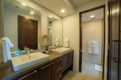 a bathroom with two sinks and a large mirror at Miramar 4E 3 bdr Ocean View in Los Suenos in Herradura