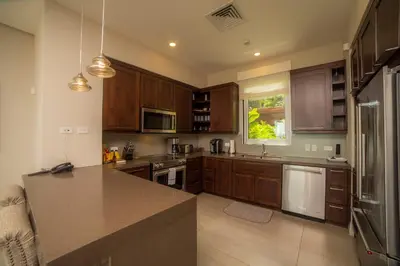 a kitchen with wooden cabinets and a counter top at Miramar 4E 3 bdr Ocean View in Los Suenos in Herradura