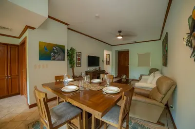 a dining room with a table and a couch at Veranda 3B 2 bdr Garden View in Los Suenos in Herradura