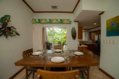 a dining room with a wooden table and chairs at Veranda 3B 2 bdr Garden View in Los Suenos in Herradura