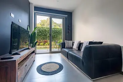 a living room with a black couch and a flat screen tv at Urban Flats Studios by Corporate Stays in San José