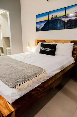 a bedroom with a bed with white sheets and pillows at Urban Flats Studios by Corporate Stays in San José