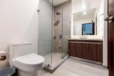 a bathroom with a toilet and a glass shower at Urban Flats Studios by Corporate Stays in San José