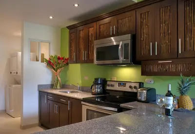 a kitchen with wooden cabinets and a stove and microwave at Cabo Velas Estates in Playa Grande