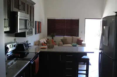 a kitchen with a counter top and a living room at Cabo Velas Estates in Playa Grande