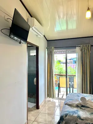 a bedroom with a bed and a flat screen tv at Hotel Arenal Rabfer in Fortuna