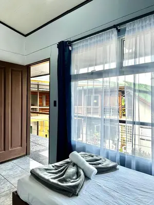 a bed in a room with a large window at Hotel Arenal Rabfer in Fortuna