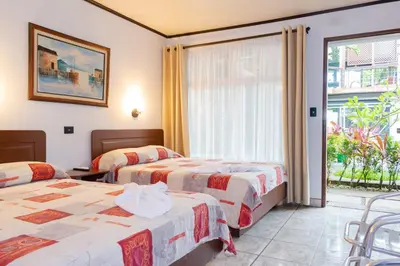 a hotel room with two beds and a window at Hotel Arenal Rabfer in Fortuna