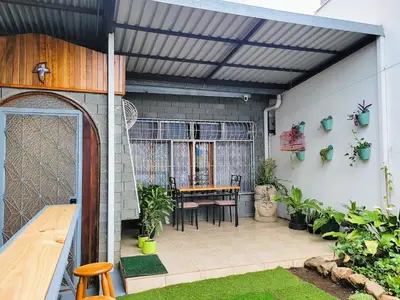 an outdoor patio with a table and chairs at Casa Flores in Heredia