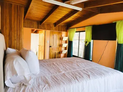 a bedroom with a white bed in a room at Casa Flores in Heredia