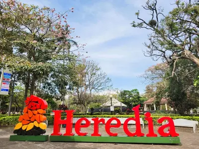 a sign that reads heroia in a park at Casa Flores in Heredia