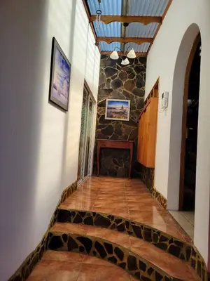 a staircase in a house with a stone wall at Casa Flores in Heredia