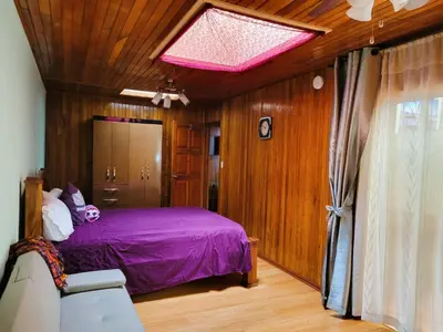 a bedroom with a bed with a purple bedspread at Casa Flores in Heredia