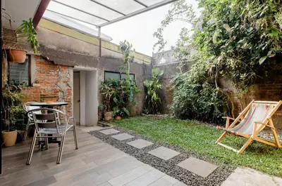 a patio with a table and chairs in a garden at Casa Mundo in San José