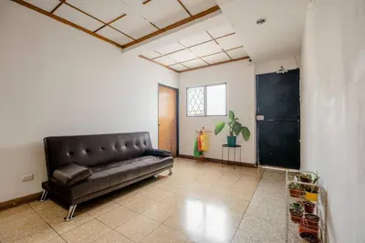 a living room with a leather couch in a room at Casa Mundo in San José