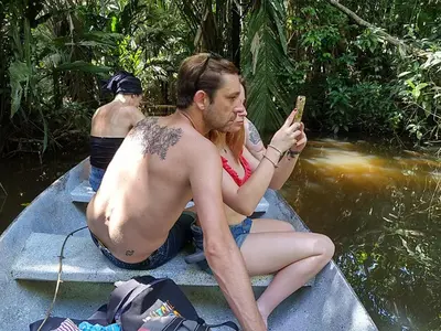 a man and a woman sitting in a boat in the water at Casa Chilamates 2.0 in Tortuguero