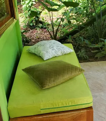 a green bench with a pillow on top of it at Casa Chilamates 2.0 in Tortuguero