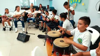 a group of young people playing drums and instruments at Casa Chilamates 2.0 in Tortuguero