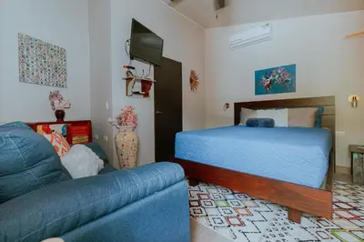 a living room with a bed and a couch at Oasis Diverse Adult Retreat in Quepos