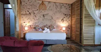 a bedroom with a bed and two chairs and a table at Space One in Manuel Antonio