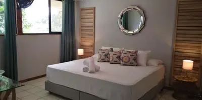 a bedroom with a bed with pillows and a mirror at Space One in Manuel Antonio