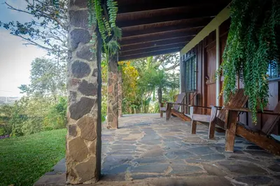 a porch of a house with benches on it at Vista Lago Arenal in Piedras