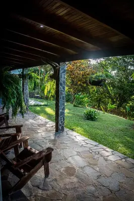 a stone patio with a table and a bench at Vista Lago Arenal in Piedras