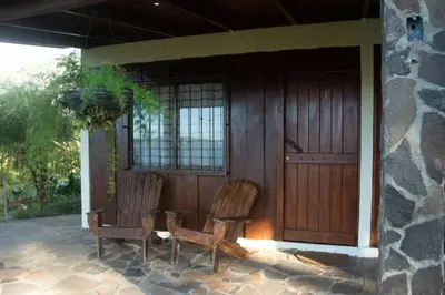 two chairs and a table in front of a house at Vista Lago Arenal in Piedras