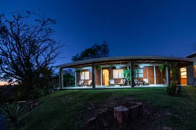 a home with a round roof on a green lawn at Vista Lago Arenal in Piedras