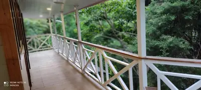 a balcony with a view of a forest at Green House by W. in Heredia