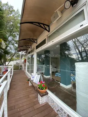 a screened in porch with a bench and flowers on it at Green House by W. in Heredia