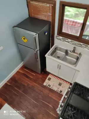 a small kitchen with a sink and a refrigerator at Green House by W. in Heredia