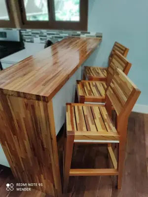 a wooden bar with two chairs around it at Green House by W. in Heredia