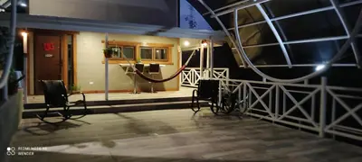 a room with a stage with two chairs in front of a building at Green House by W. in Heredia