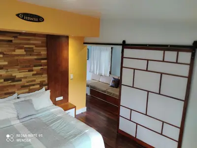 a bedroom with a bed and a bench in it at Green House by W. in Heredia