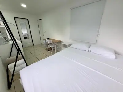 a bedroom with a white bed and a table at La Fonda Apartments in Fortuna