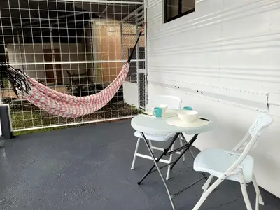 a porch with a hammock and a table and chairs at La Fonda Apartments in Fortuna