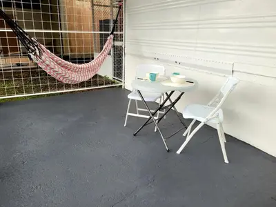 a table and two chairs and a hammock on a porch at La Fonda Apartments in Fortuna