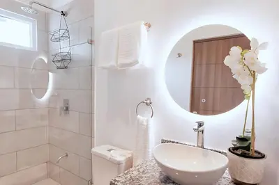 a white bathroom with a sink and a mirror at Modern 2BR Condo - minutes from Jaco Beach - PRIME location in Jacó