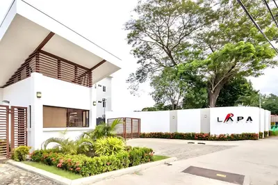 a white building with a la agency sign on it at Modern 2BR Condo - minutes from Jaco Beach - PRIME location in Jacó
