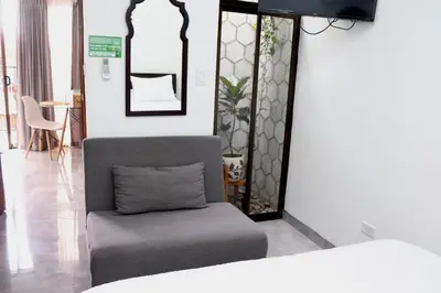 a room with a chair and a bed at Airport SJO Residence Cars4Rent 