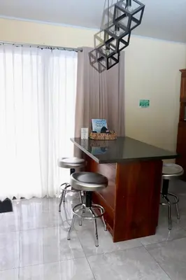 a kitchen with a counter with stools in a room at Airport SJO Residence Cars4Rent 
