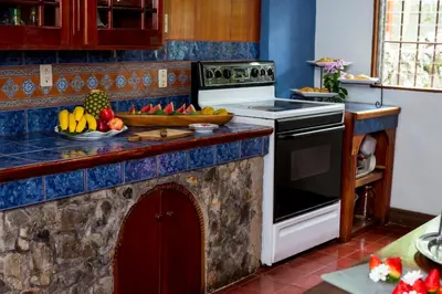a kitchen with a stove and a counter with fruit on it at Casa de Piedra Escazú in San José