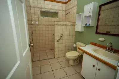 a bathroom with a shower and a toilet and a sink at Casa de Piedra Escazú in San José