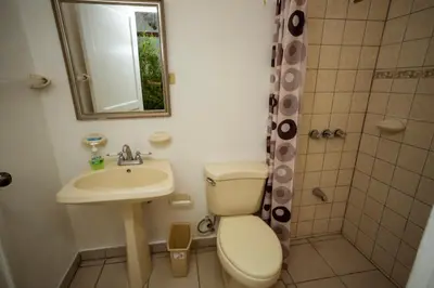 a bathroom with a toilet and a sink and a shower at Casa de Piedra Escazú in San José