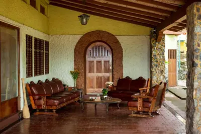 a living room with leather furniture and a table at Casa de Piedra Escazú in San José