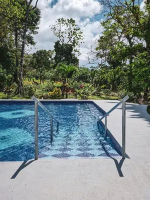 a swimming pool with blue water and trees in the background at Cabañas Don Ramiro in Colonia Dos Ríos