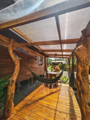 a hammock on a porch of a house at Cabañas Don Ramiro in Colonia Dos Ríos